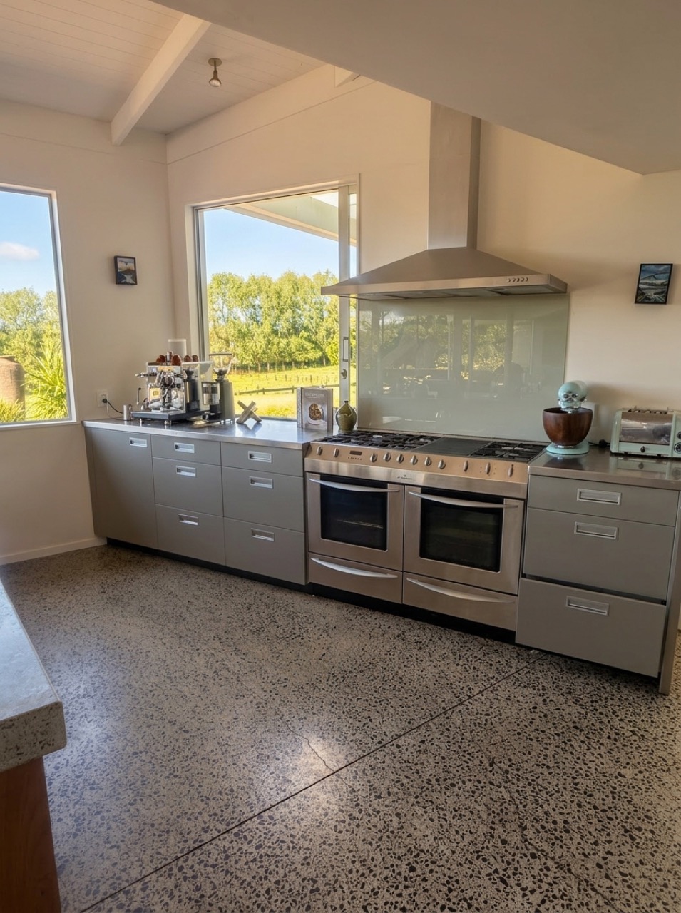 Chef's kitchen range wall featuring ECM espresso machine, coffee grinder, wide 6-burner double-oven range, and KitchenAid stand mixer